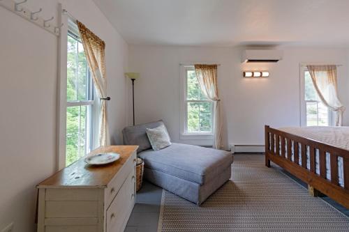 a bedroom with a bed and a chair and windows at The Woodbine Inn in Palenville