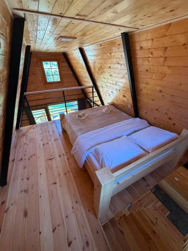 a bedroom with a bed in a wooden cabin at Vikendice Pod Hum Kučka Korita in Korita