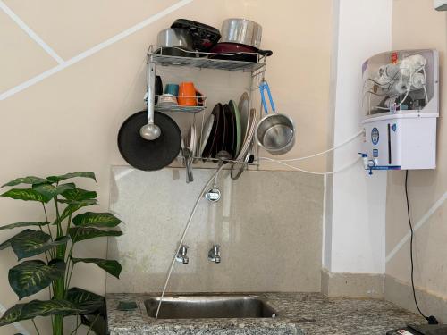 a kitchen with a sink and a shelf with utensils at Drip Home Stay AKTU in Lucknow