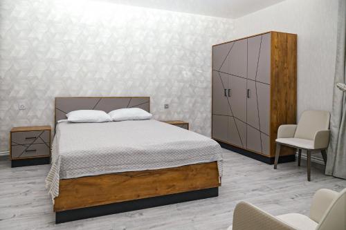 a bedroom with a bed and a cabinet and a chair at EVORI Guesthouse in Dilijan