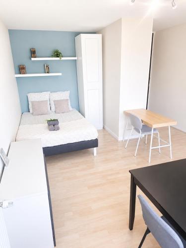 a bedroom with a bed and a table and a desk at L'Élégant - 2 Voyageurs in Reims
