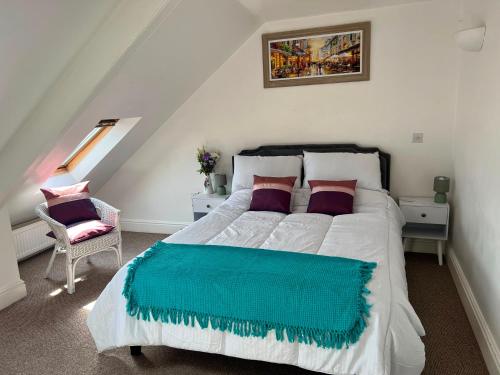 a bedroom with a large white bed and a chair at Penzance Central 1 & 2 Bedroom flats in Penzance