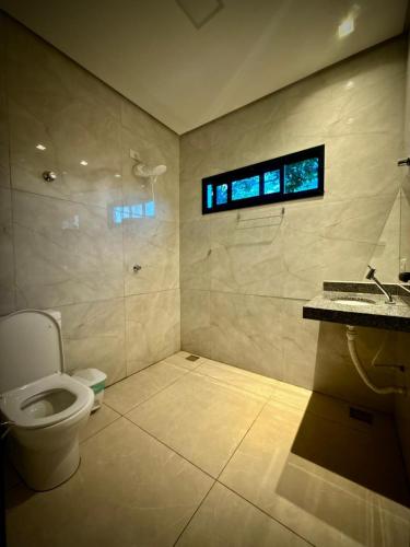 ein Badezimmer mit Toilette, Waschbecken und Fenster in der Unterkunft Bee Cool Hostel in Palmas