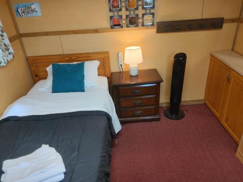 a bedroom with two beds and a table with a lamp at Cozy Tree House in Saint John
