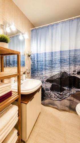 a bathroom with a sink and a shower curtain at 2 bedroom flat 100m from the beach with huge terrace in Moncófar