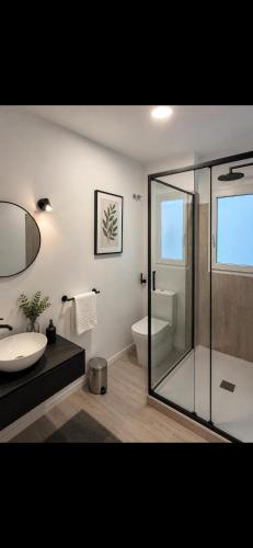 a bathroom with a glass shower and a toilet at H SENDA ReAL in Alcuéscar