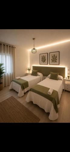 a bedroom with two beds in a room at H SENDA ReAL in Alcuéscar