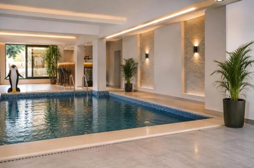 a pool in a house with a woman standing next to it at Семеен хотел Forest Retreat Mountain Resort in Kyustendil