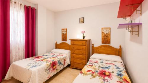 two beds in a bedroom with red curtains at 2 bedroom flat 100m from the beach with huge terrace in Moncófar