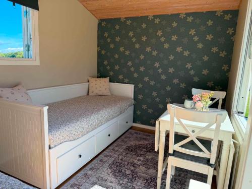 a small bedroom with a bed and a table at Stuga 1 Lillstugan in Ängelholm