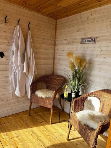 two wicker chairs and a table in a sauna at Stuga 1 Lillstugan in Ängelholm