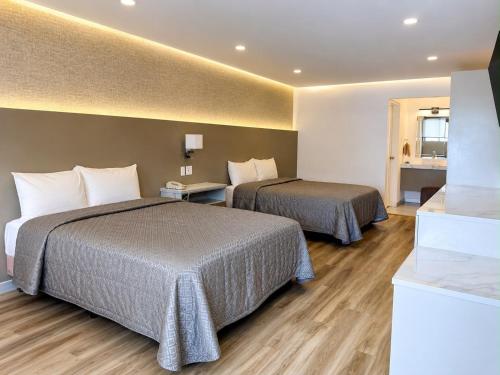 a hotel room with two beds and a window at Hotel Villa del Sol in Ciudad Juárez