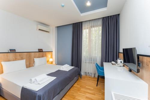 ein Hotelzimmer mit Bett und Fernseher in der Unterkunft Alpha by Horizon Hotels, Yerevan in Yerevan