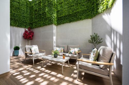 a room with chairs and a table and a green wall at AZUL HOME SUITES Estepona in Estepona