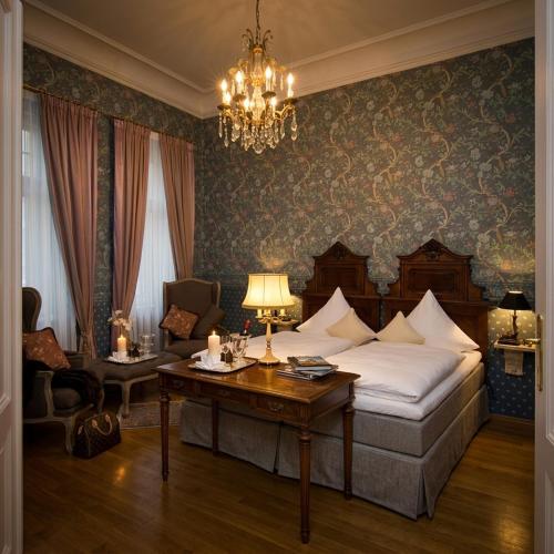 a bedroom with a bed and a table and a chandelier at Der Platengarten in Ansbach