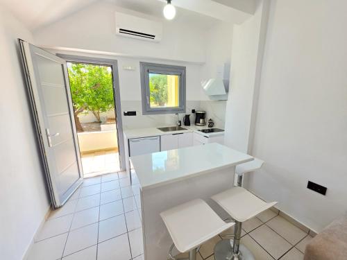 a white kitchen with a counter and a sink at Studio Popi in Marathokampos