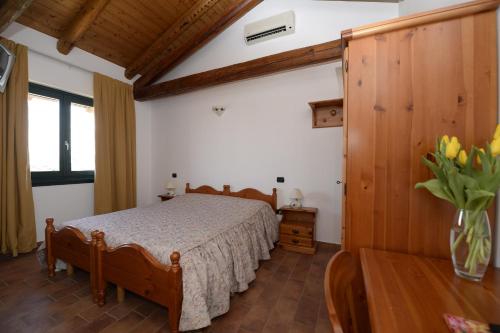 a bedroom with a bed and a vase of flowers at Agriturismo Le oche selvatiche in Lauzacco
