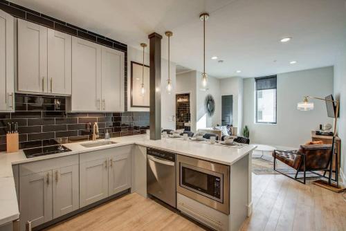 a kitchen with white cabinets and stainless steel appliances at Chic Tennyson St Retreat - Walk to Shops & Cafes in Denver