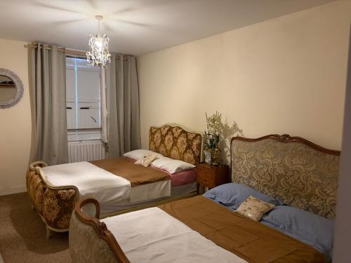 a bedroom with two beds and a window and a chair at Chez Paulet A welcome break for peace and tranquility - route C27 in Lobard