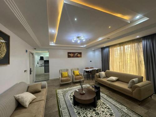 a living room with two couches and a table at Peev Apartements in Abuja