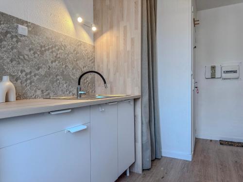a kitchen with white cabinets and a sink at Le Charles - Gare - CEA - STMicro in Fontaine