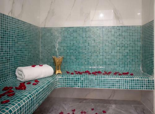 a green tiled bathroom with red roses on a counter at Dar Lala Fatma in Le Lido