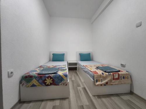 two beds in a room with white walls at N&L apartments in Strumica