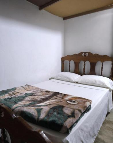 a bedroom with a bed with a blanket on it at Acogedora cabaña Hospedaje Mérida in Mérida