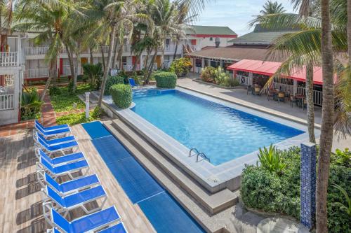 an overhead view of a swimming pool with blue lounge chairs at Decameron San Luis - All Inclusive in San Andrés