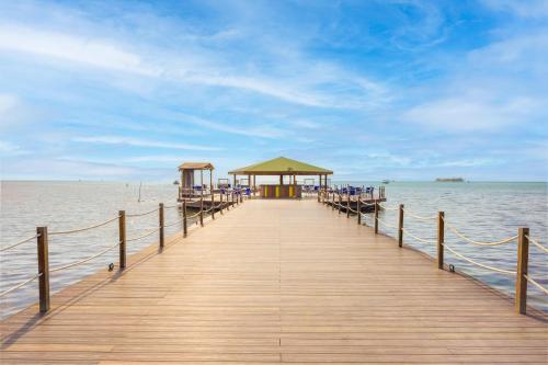 a wooden pier with chairs and a gazebo on the water at Decameron Marazul - All Inclusive in San Andrés