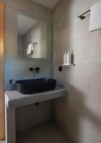 a bathroom with a black sink and a mirror at JIRONI VILLA in Nikiti