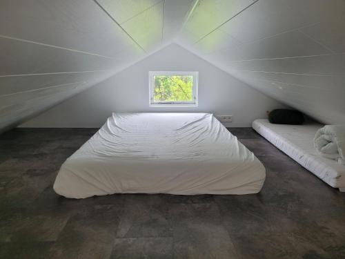 a bedroom with a large white bed and a window at Thingvellir Lake Cottage in Veiðilundur