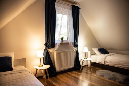 a attic bedroom with two beds and a window at Siedlisko pod lipą in Józefów