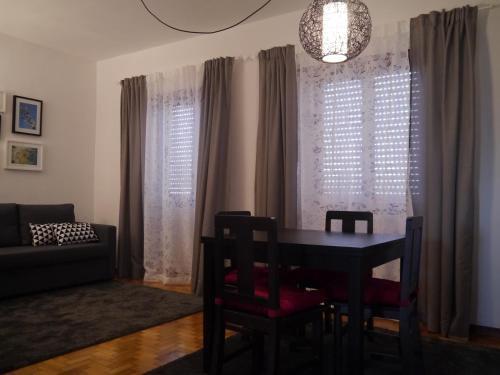 a dining room with a table and chairs and a couch at Apartamento Boavista in Vila Nova de Gaia