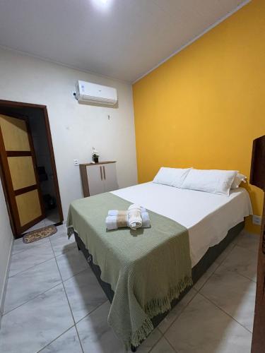 ein Schlafzimmer mit einem Bett und einem Tisch, auf dem ein Handtuch liegt in der Unterkunft Chalés do mar in Icapuí