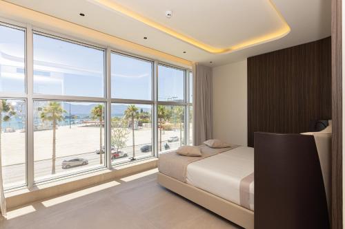 a bedroom with a bed and a large window at Quartz Hotel Vlore in Vlorë