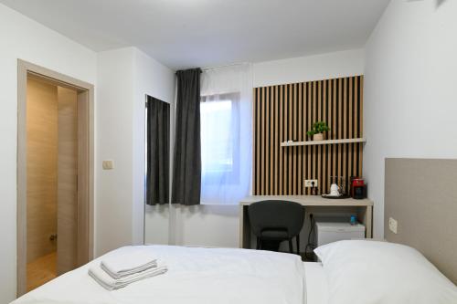 a bedroom with a bed and a desk with a chair at Terra rossa rooms in Čepljani