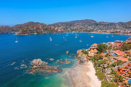 une vue aérienne d'une plage avec des bateaux dans l'eau dans l'établissement Hotel Adelita, Zihuatanejo, à Zihuatanejo
