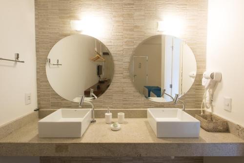 a bathroom with two sinks and a large mirror at Pousada da Villa in Fernando de Noronha