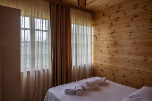 a bedroom with wooden walls and a bed with towels at Laguna Villa Cottages in Chinkadzeebi