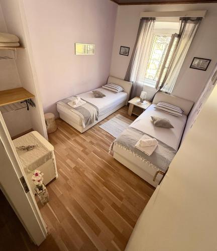 a small room with two beds and a window at Apartmani Vela Luka in Vela Luka