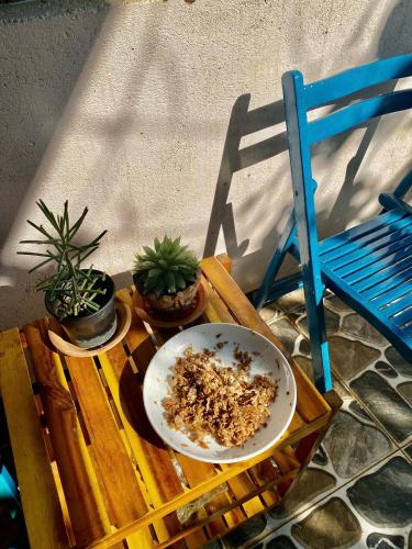 a table with a bowl and plants on it next to a chair at Mindy s Home in Lien Nghiia