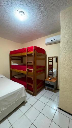 a bedroom with bunk beds in a room with a ceiling at Por do Sol Praia Hotel in Fortaleza