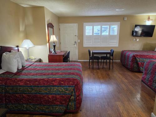 a hotel room with two beds and a table at San Luis Inn and Suites in San Luis Obispo