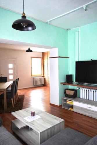 a living room with a table and a tv at Moderne offene Wohnung in Bad Sulza