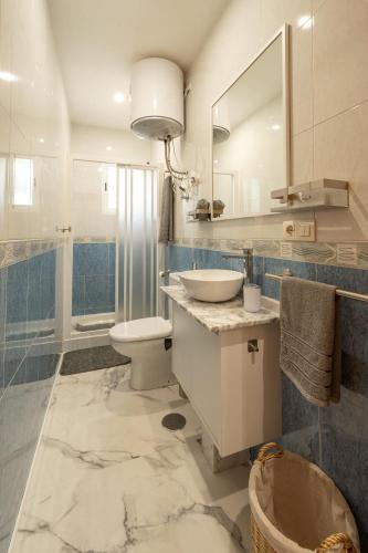 a bathroom with a sink and a toilet and a mirror at Apartamento By Llu in Alcalá la Real