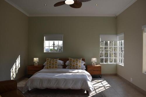 a bedroom with a bed and a ceiling fan at Villa Euris Guesthouse in Brits
