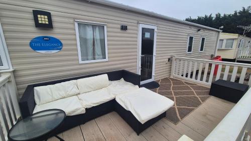 a couch sitting on the deck of a tiny house at K & K Caravan Southview in Skegness
