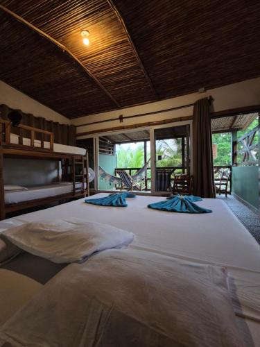 a large bedroom with a large bed with a large window at El Marabu Chill'n Surf in Aposentillo