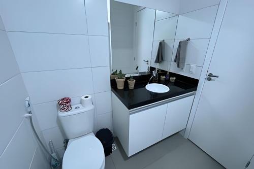 a white bathroom with a toilet and a sink at Studio Nova Betânia - Barreto - in Mossoró